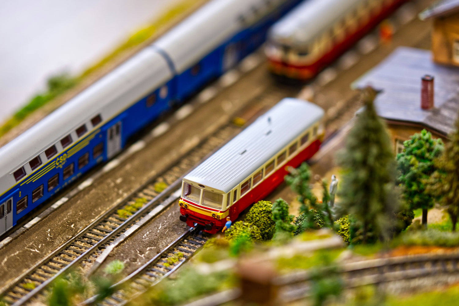 Trois trains miniatures en gare.