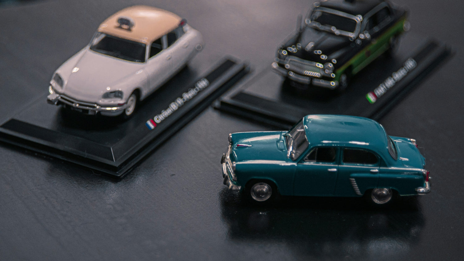 Trois voitures de collection miniatures.